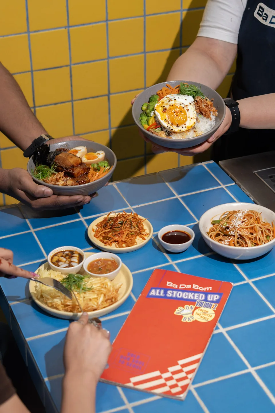 Overhead view of colourful plates on a blue tiled restaurant table
